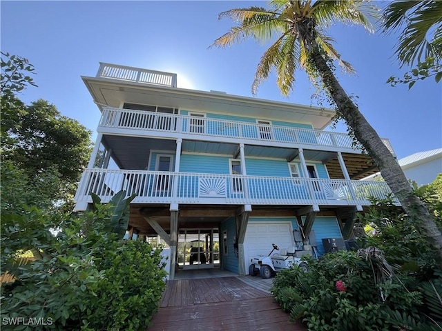 beach home featuring a balcony, a garage, and a carport