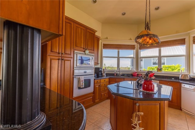 kitchen featuring light tile patterned flooring, sink, a kitchen island, and white appliances