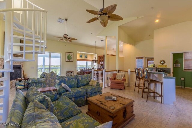 tiled living room with ceiling fan and a towering ceiling