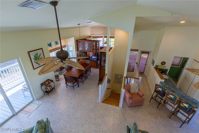 tiled living room with plenty of natural light, ceiling fan, and high vaulted ceiling