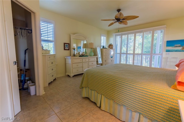 bedroom featuring light tile patterned flooring, a spacious closet, a closet, and ceiling fan