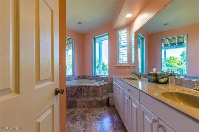 bathroom with tile patterned flooring, vanity, and a tub to relax in