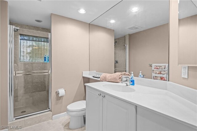 bathroom with vanity, toilet, tile patterned floors, and walk in shower