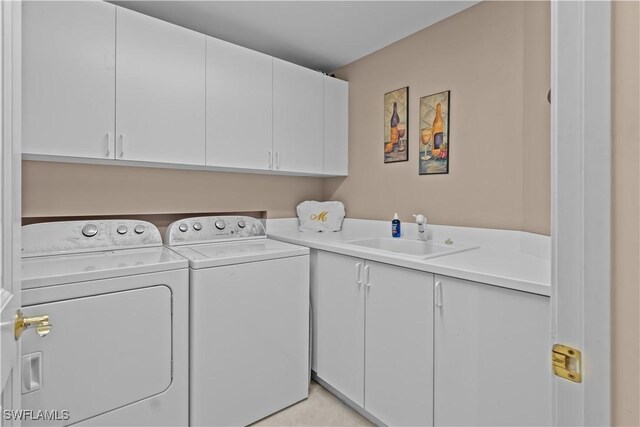 washroom featuring cabinets, sink, and washing machine and clothes dryer