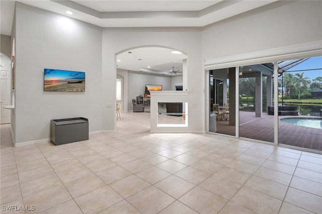 unfurnished living room with ceiling fan and light tile patterned floors