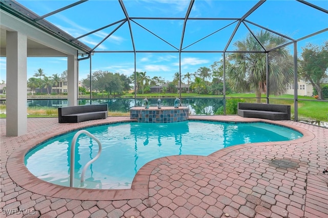 view of pool with a lanai, a patio, pool water feature, a hot tub, and a water view