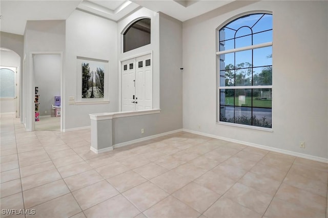15120 Blackhawk Dr, Fort Myers, FL 33912 - empty room with light tile patterned floors, arched walkways, and a towering ceiling