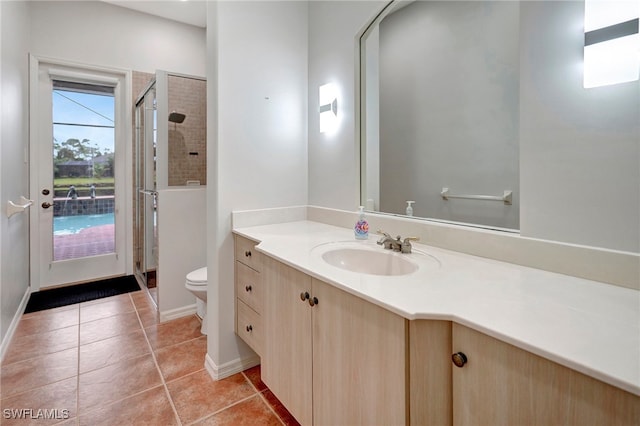 bathroom with vanity, toilet, an enclosed shower, and tile patterned flooring