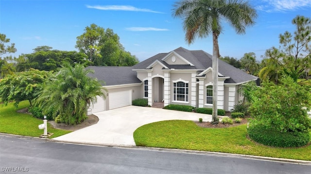 view of front of home with a garage and a front lawn