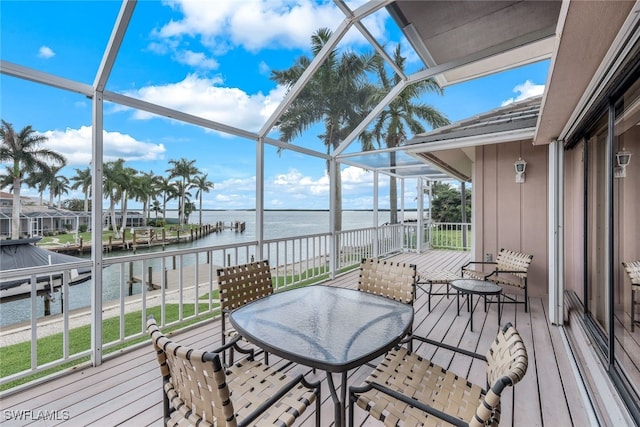 deck featuring a dock, glass enclosure, and a water view