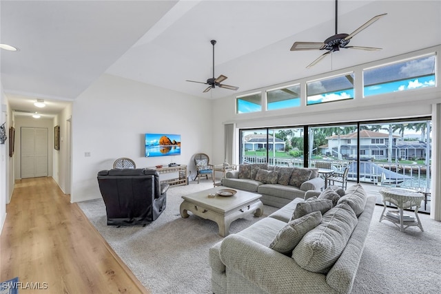 living room featuring ceiling fan, high vaulted ceiling, and light hardwood / wood-style floors