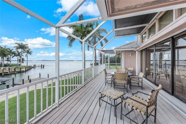 deck featuring a dock, glass enclosure, and a water view