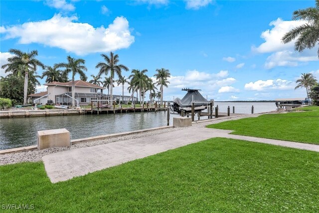 view of dock featuring a lawn and a water view