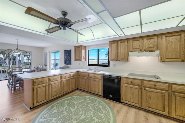 kitchen with light hardwood / wood-style flooring, sink, pendant lighting, black appliances, and kitchen peninsula