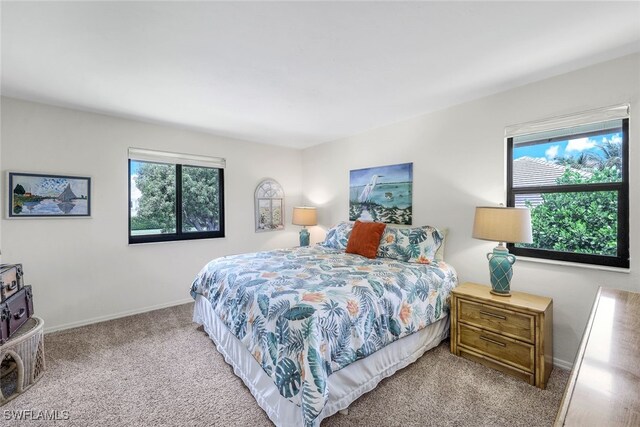 bedroom with multiple windows and light colored carpet