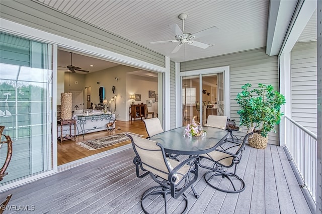 wooden terrace featuring a ceiling fan and outdoor dining area