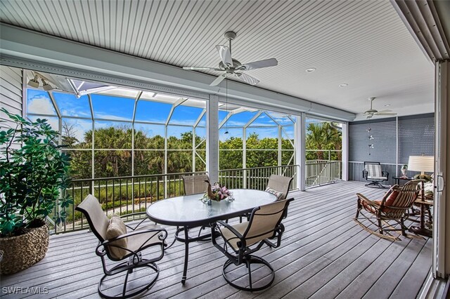 wooden deck with a lanai and ceiling fan