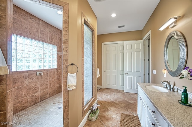 bathroom with vanity and a tile shower