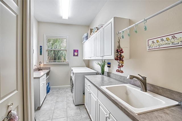 clothes washing area with washer and dryer, cabinets, sink, and light tile patterned floors