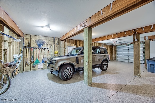 garage featuring wood walls and a garage door opener