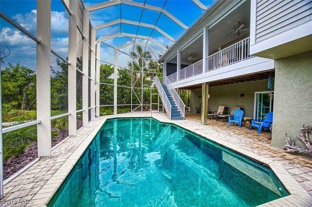 view of pool with a lanai, ceiling fan, and a patio area