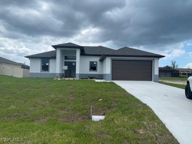 prairie-style home featuring a garage and a front lawn