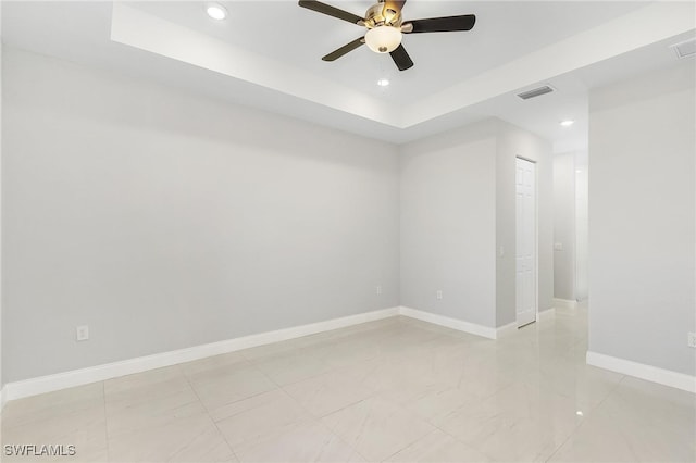 spare room featuring light tile patterned floors, a raised ceiling, and ceiling fan