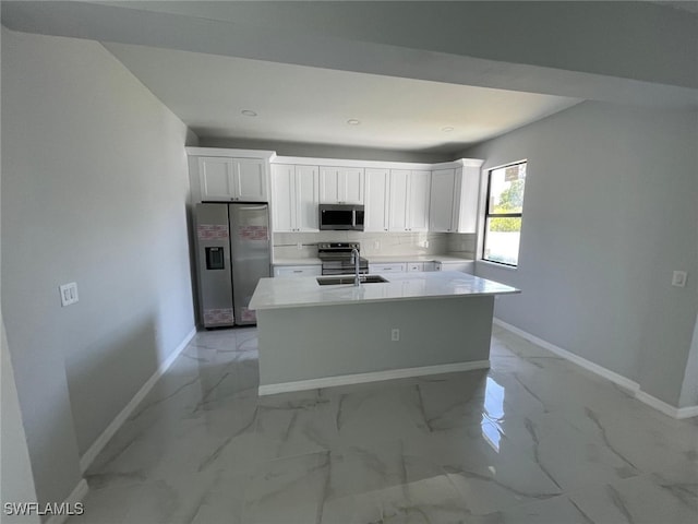 kitchen with white cabinets, stainless steel appliances, a kitchen island with sink, and sink