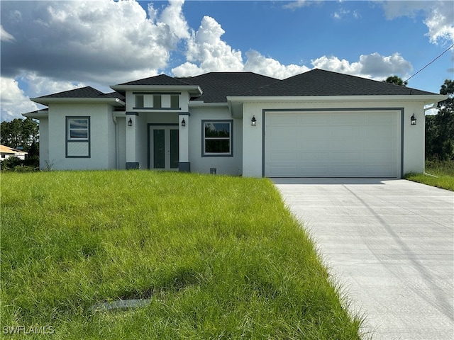 prairie-style home with a front yard and a garage