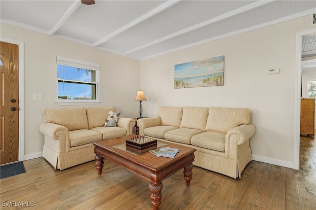 living room featuring beam ceiling, baseboards, and wood finished floors