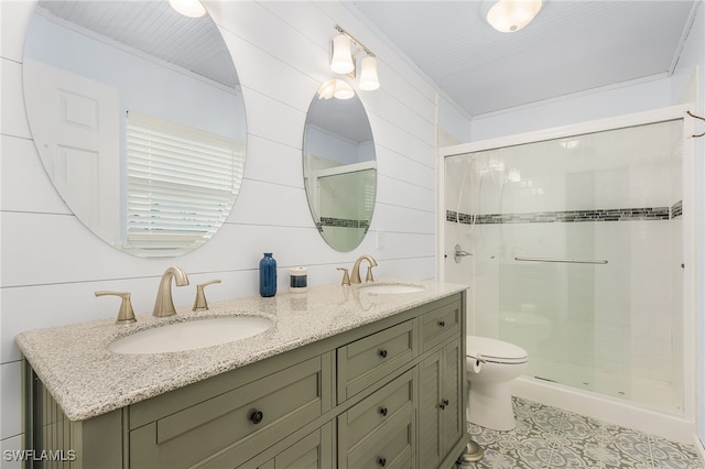 bathroom featuring a sink, a shower stall, toilet, and double vanity