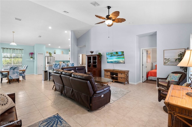 living room with ceiling fan, vaulted ceiling, and light tile patterned flooring