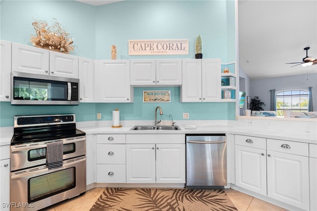 kitchen featuring ceiling fan, white cabinetry, sink, light tile patterned flooring, and stainless steel appliances