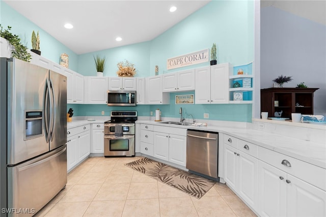 kitchen featuring white cabinetry, light stone countertops, light tile patterned floors, sink, and stainless steel appliances