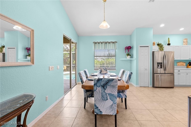 dining area featuring light tile patterned flooring and lofted ceiling