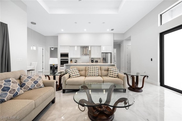 living room featuring marble finish floor, baseboards, a raised ceiling, and recessed lighting