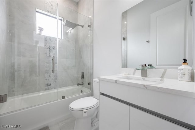 full bath with enclosed tub / shower combo, vanity, and toilet