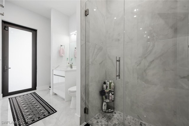 bathroom with toilet, a shower stall, baseboards, and vanity