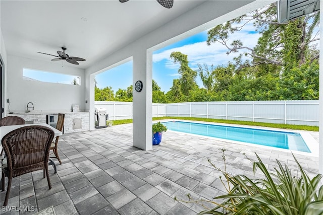 view of pool featuring area for grilling, ceiling fan, sink, and exterior kitchen