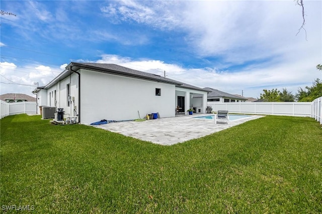 rear view of house with a lawn, a patio area, and a fenced backyard