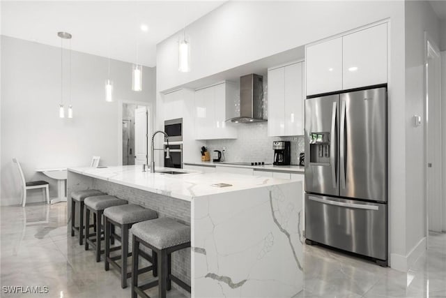 kitchen with white cabinetry, appliances with stainless steel finishes, wall chimney range hood, decorative backsplash, and modern cabinets