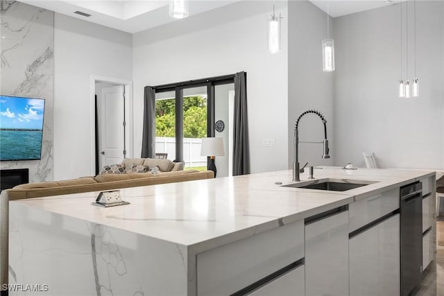 kitchen featuring light stone counters, a large island, white cabinetry, a sink, and modern cabinets