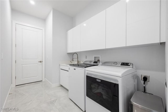 clothes washing area with cabinet space, baseboards, marble finish floor, washing machine and dryer, and a sink