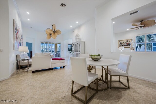 tiled dining space featuring ceiling fan and crown molding