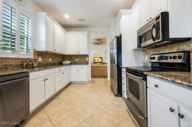 kitchen featuring backsplash, sink, white cabinetry, light tile patterned floors, and stainless steel appliances