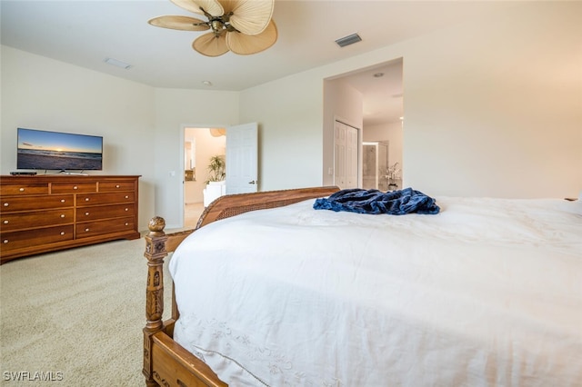 carpeted bedroom featuring ceiling fan, a closet, and ensuite bathroom