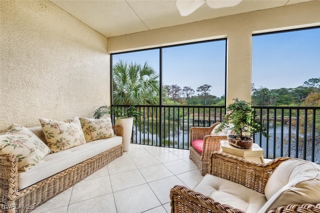 sunroom with ceiling fan, a healthy amount of sunlight, and a water view