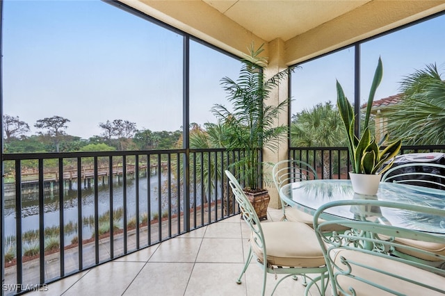 sunroom / solarium featuring a water view