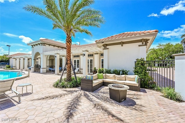 exterior space featuring a pergola, an outdoor living space with a fire pit, and a fenced in pool