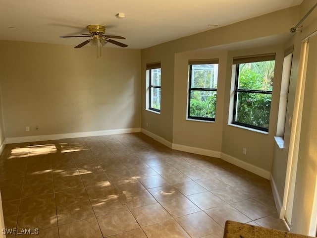 empty room with tile patterned flooring and ceiling fan